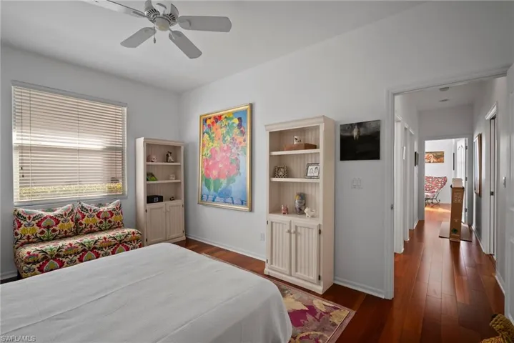 Bedroom with dark hardwood / wood-style floors and ceiling fan