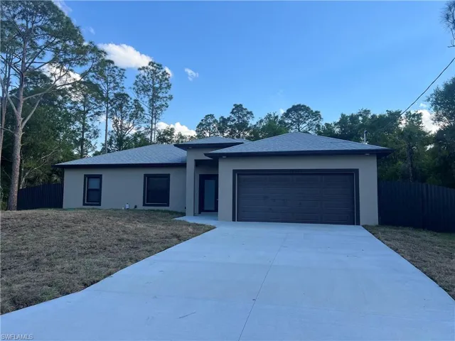 Single story home with driveway, an attached garage, fence, and stucco siding
