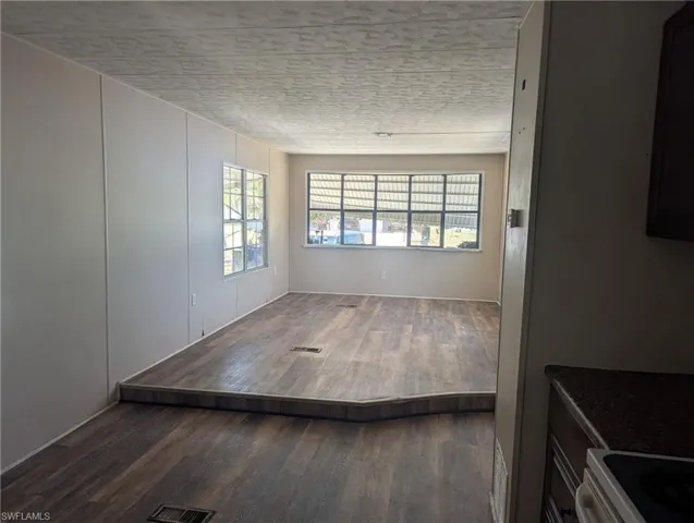 Unfurnished room featuring visible vents, wood finished floors, and a textured ceiling