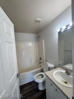 Full bathroom featuring shower / tub combination, vanity, hardwood / wood-style flooring, and toilet