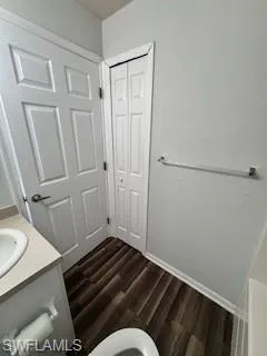 Bathroom with toilet, vanity, and hardwood / wood-style flooring