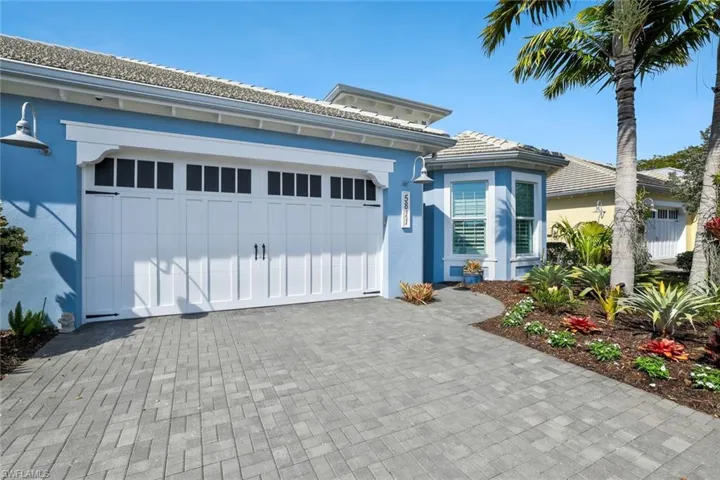 View of front of property with driveway, an attached garage, stucco siding, and a tiled roof