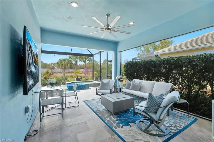 Sunroom with ceiling fan, an outdoor living space, a patio area, and a hot tub