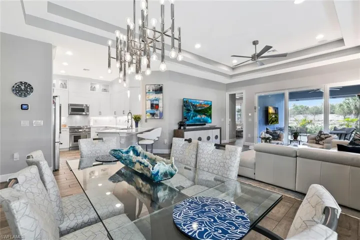 Dining space featuring a tray ceiling, ceiling fan, and recessed lighting