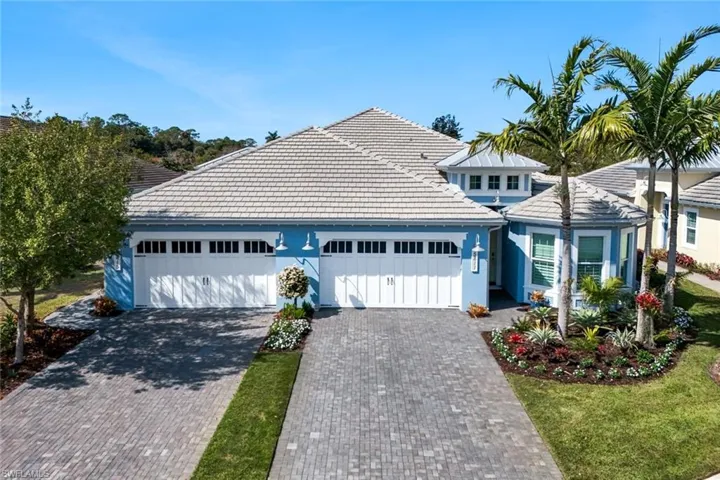View of front of house with a tiled roof, driveway, an attached garage, and stucco siding