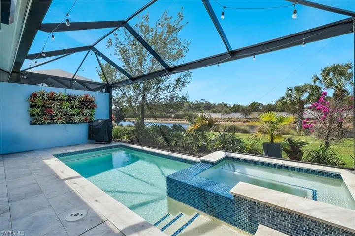 Combined pool / hot tub featuring area for grilling, a sunroom, and a patio