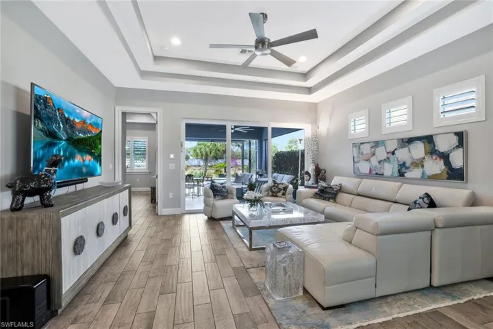 Living room featuring ceiling fan, wood-style tile floors, and recessed lighting