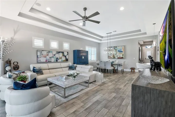 Living room with a ceiling fan, wood-style tile floors, plenty of natural light, and recessed lighting