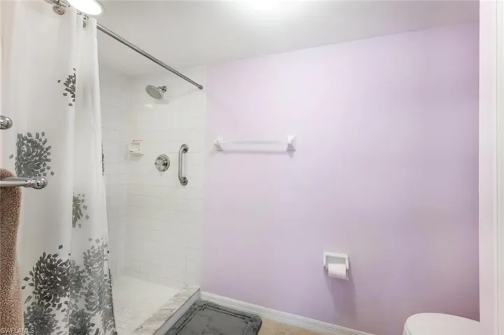Bathroom with toilet and curtained shower