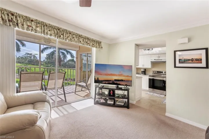 Carpeted living room featuring ornamental molding