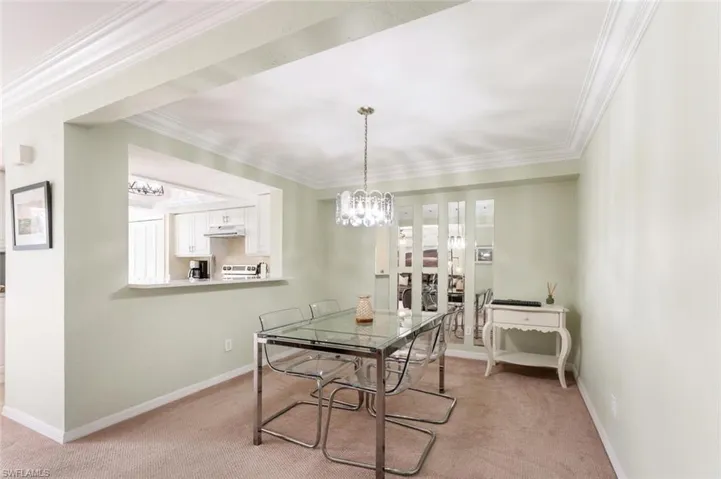 Dining area featuring light carpet and ornamental molding