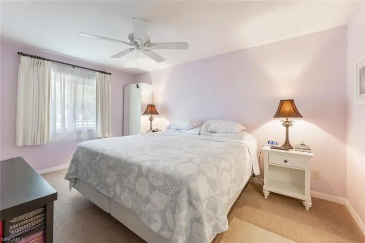 Carpeted bedroom featuring ceiling fan