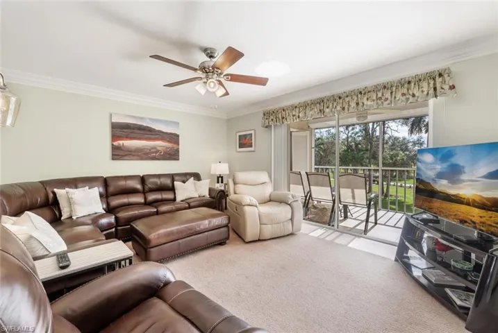 Living room featuring ceiling fan, light colored carpet, and ornamental molding
