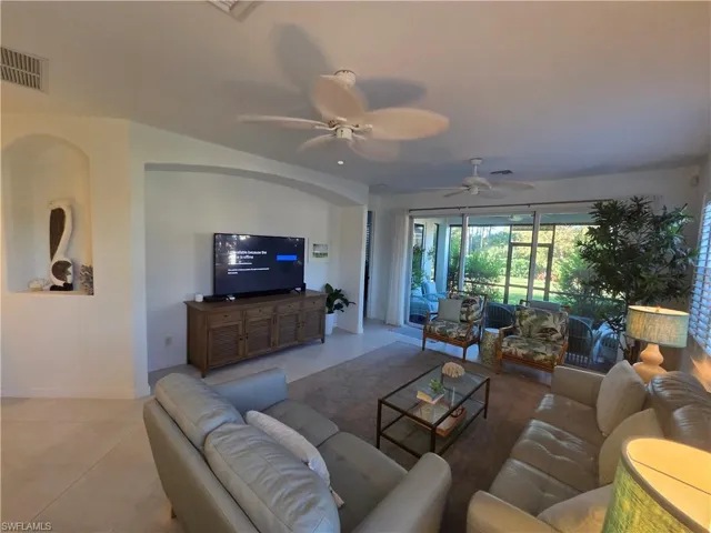 Living room with tile patterned floors and a ceiling fan