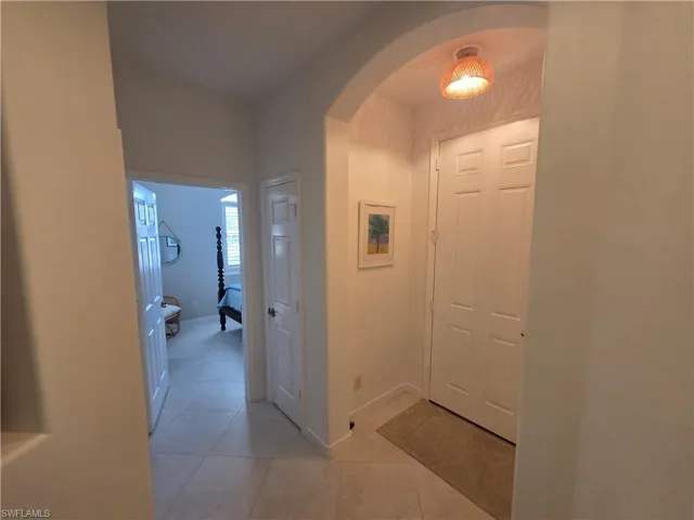 Hall with arched walkways and light tile patterned floors