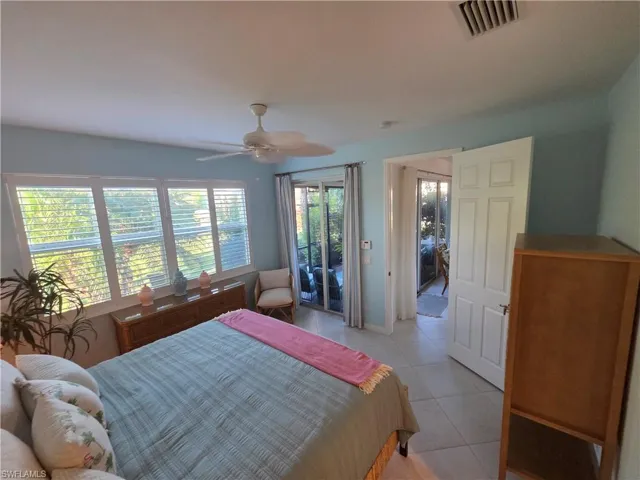 Bedroom with access to outside, a ceiling fan, light tile patterned flooring, and radiator