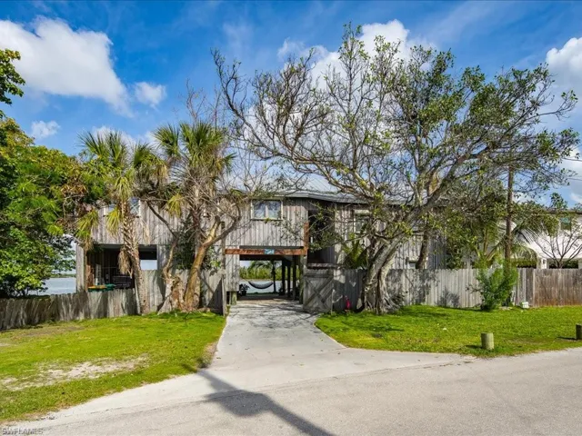 View of front of property with a carport and concrete driveway