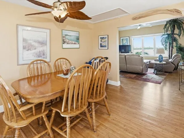 Dining space with ceiling fan, attic access, and light wood-style flooring