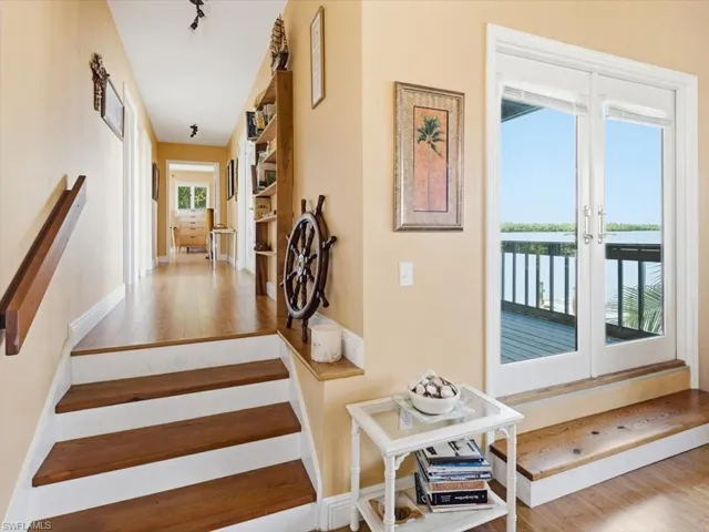 Staircase with hardwood / wood-style flooring, a water view, and french doors