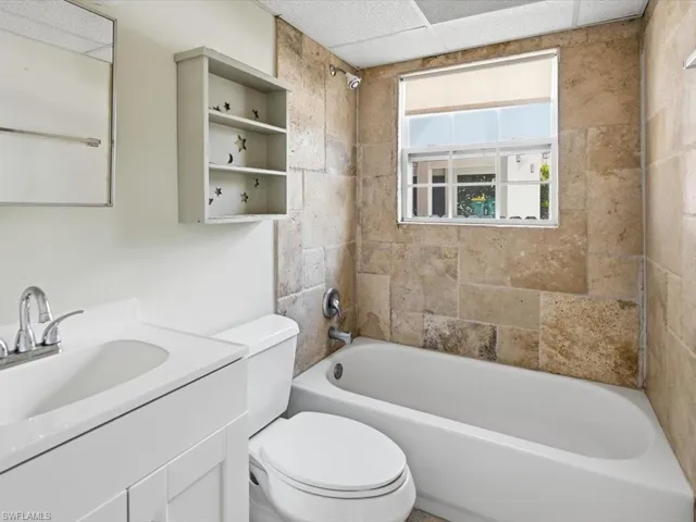 Bathroom with shower / washtub combination, vanity, and a drop ceiling