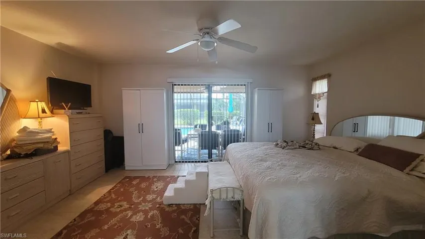 Tiled bedroom featuring access to outside and ceiling fan