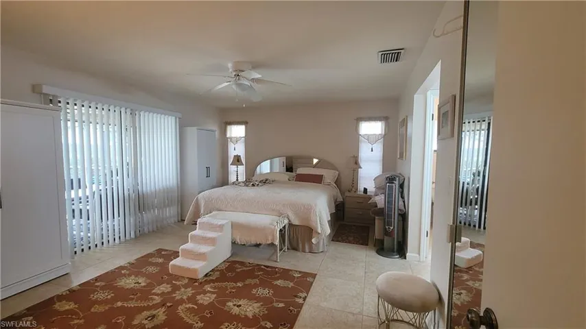 Tiled bedroom featuring ceiling fan