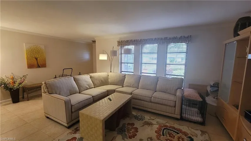 Tiled living room featuring crown molding