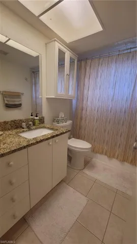 Bathroom featuring tile patterned flooring, vanity, and toilet
