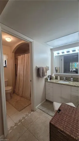 Bathroom featuring tile patterned flooring, vanity, and toilet