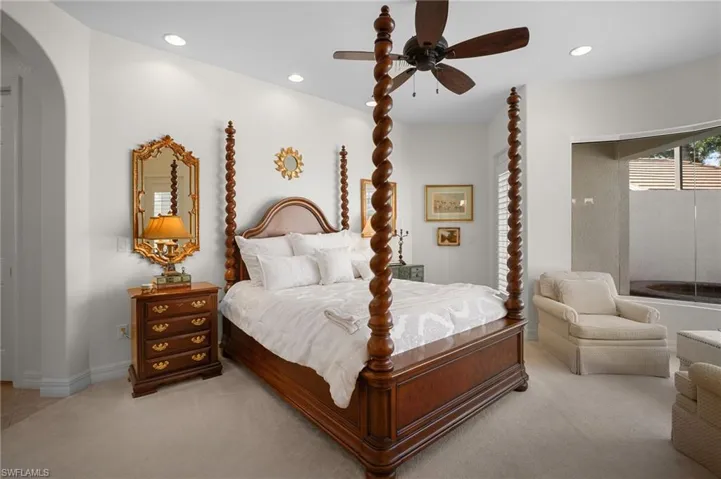 Bedroom with arched walkways, a ceiling fan, recessed lighting, and carpet flooring