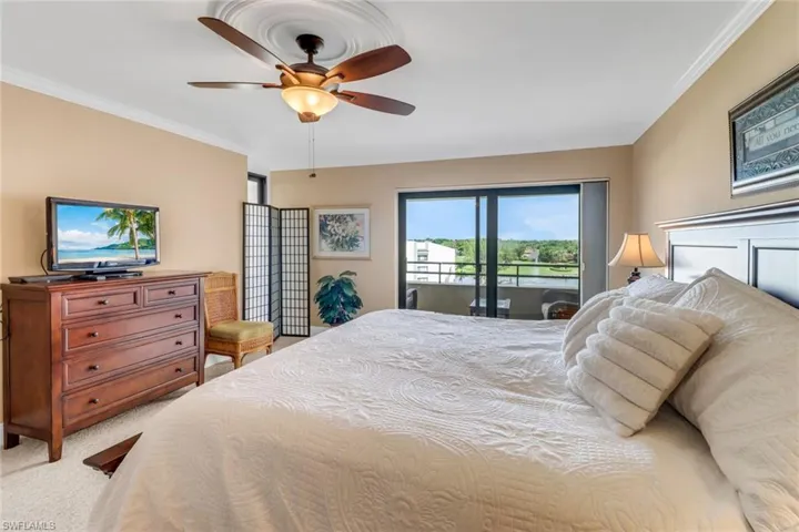 Bedroom with access to exterior, light colored carpet, crown molding, and a ceiling fan