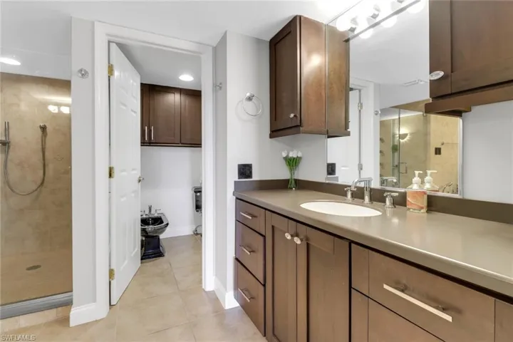 Bathroom with a shower stall, tile patterned flooring, vanity, baseboards, and recessed lighting