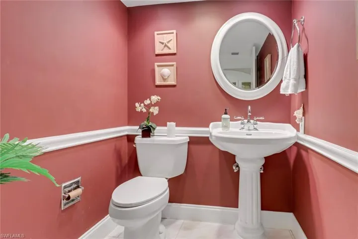 Bathroom with toilet, baseboards, and tile patterned flooring