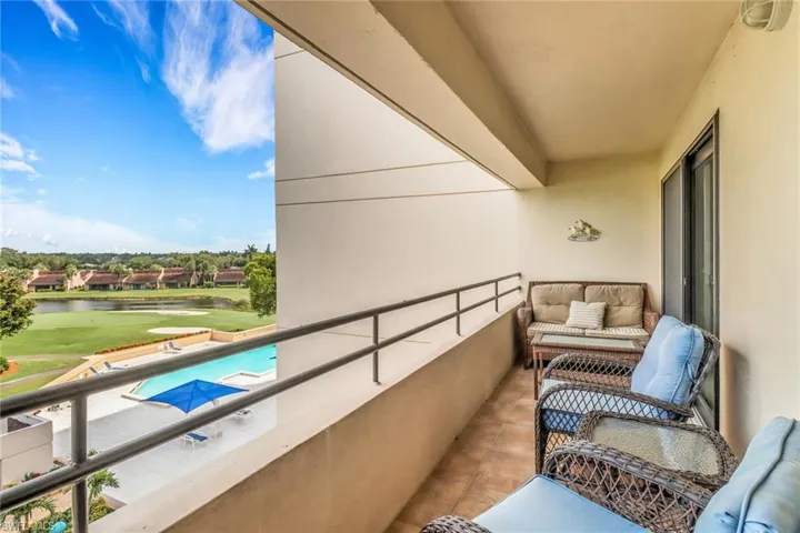 Balcony with view of golf course and a water view