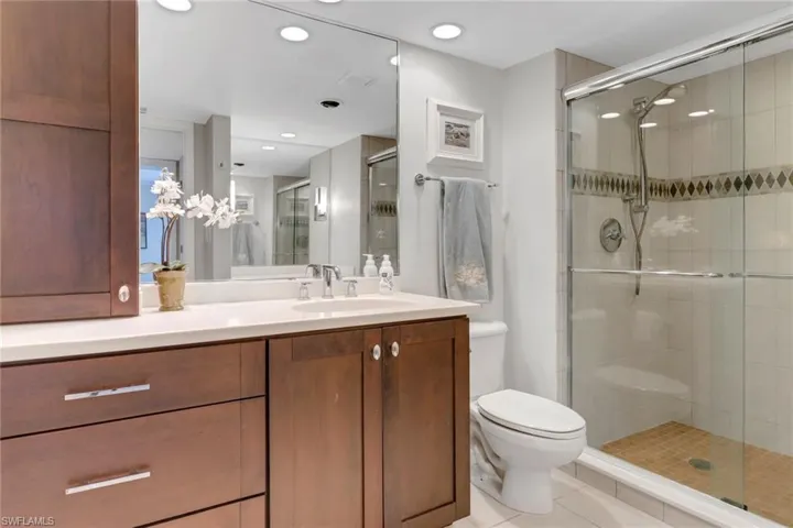 Full bath featuring a shower stall, vanity, tile patterned flooring, toilet, and recessed lighting