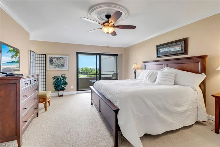 Bedroom with access to outside, light carpet, baseboards, ornamental molding, and ceiling fan