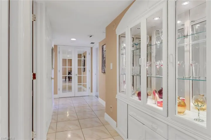 Corridor featuring french doors, baseboards, light tile patterned flooring, and recessed lighting