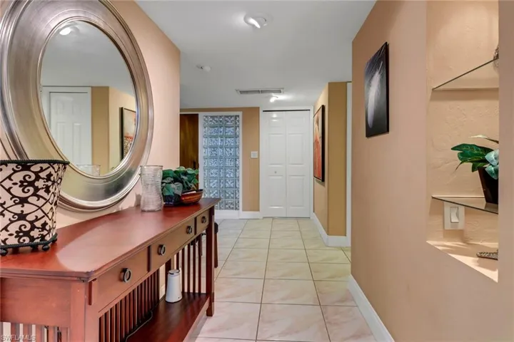 Hall with baseboards and light tile patterned floors