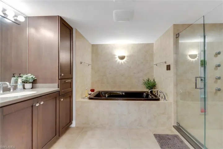 Bathroom with tile patterned flooring, vanity, a bath, and a shower stall