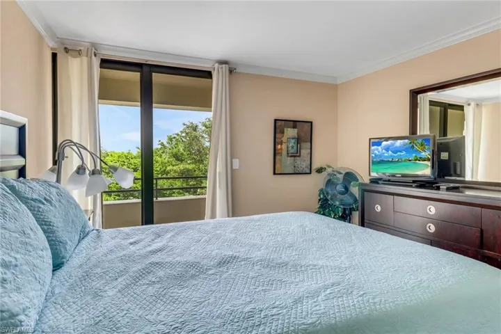 Bedroom with access to exterior and crown molding