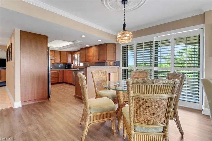 Dining area with ornamental molding, light wood-style flooring, baseboards, and recessed lighting