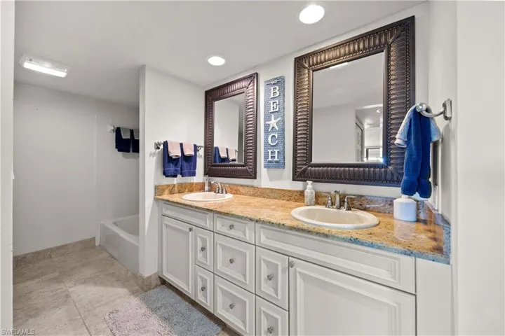 Bathroom featuring shower / bathing tub combination, tile patterned flooring, and vanity