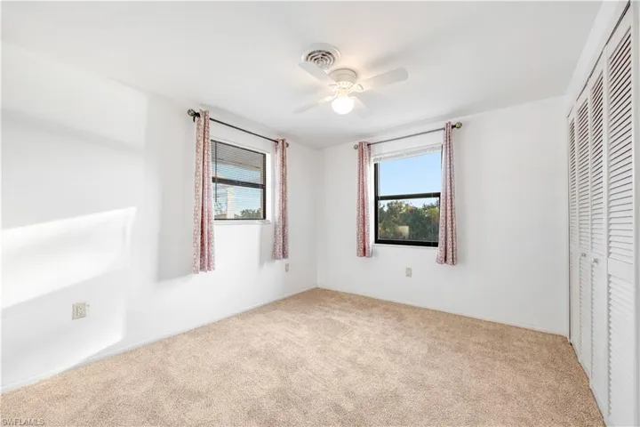 Unfurnished bedroom with a closet, ceiling fan, and light carpet