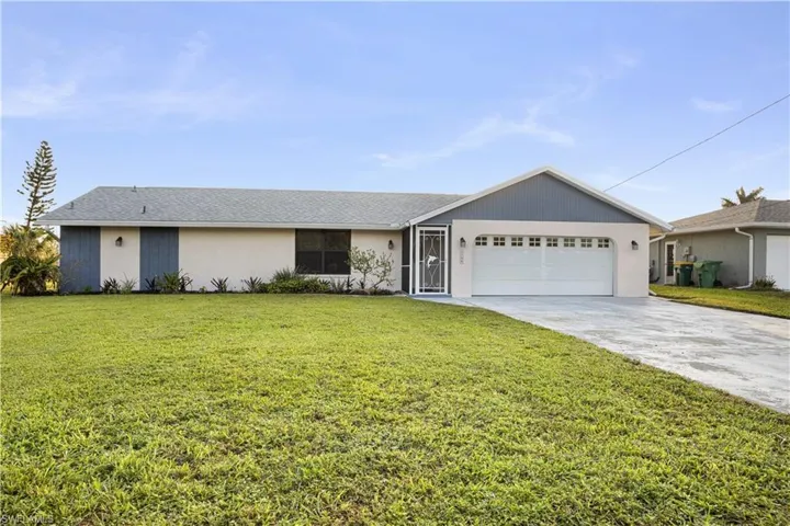 Ranch-style house with a front yard and a garage