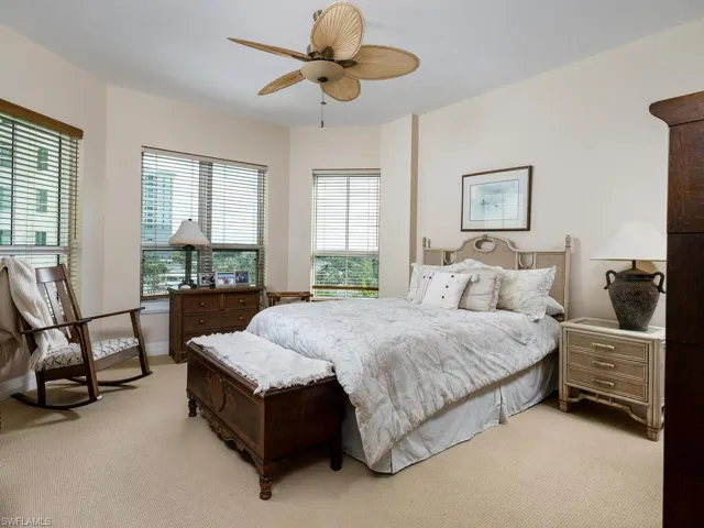 Bedroom with light colored carpet and a ceiling fan