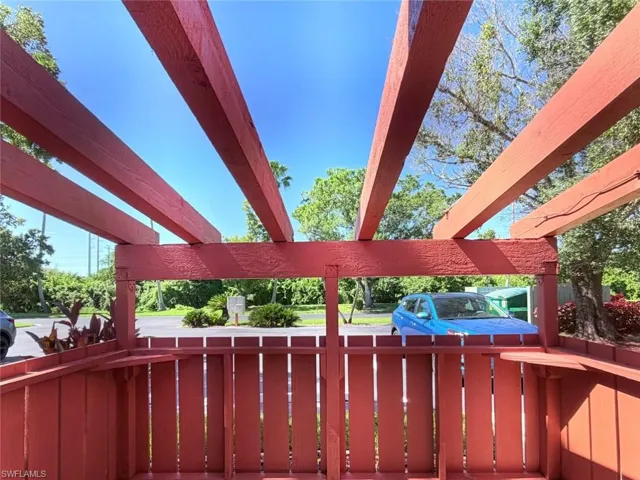 Outdoor pergola featuring timber beams and a vertical wood-plank privacy partition