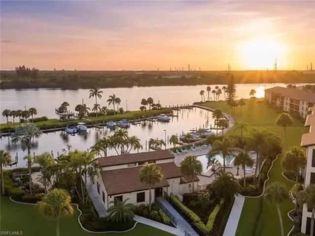 Waterfront property featuring a private marina, boat slips, paved walking paths, a swimming pool, and mature palm landscaping