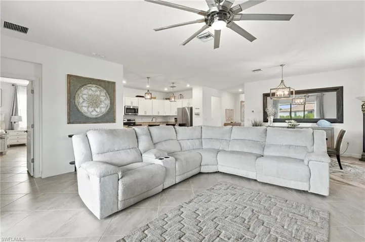 Open-concept living space featuring primary bedroom entrance, tile flooring, a ceiling fan, and recessed lighting