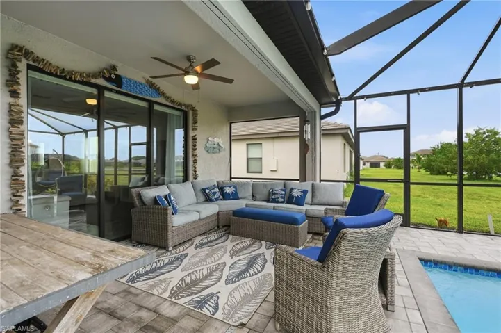 Lanai with a ceiling fan, screened enclosure, sliding glass doors, and a custom swimming pool
