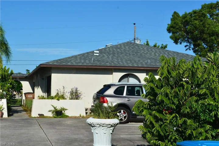 View of side of home featuring roof with shingles and stucco siding